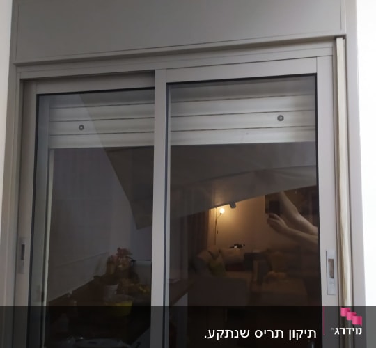 תריסים אפורים סגורים בחלון זכוכית כפול